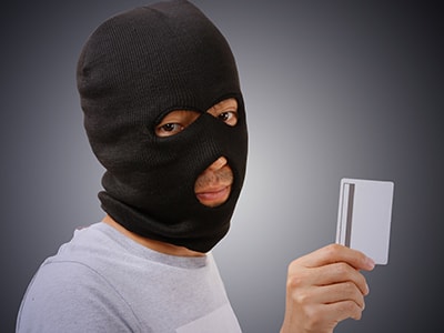 クレジットカード情報をスキミングする犯罪者